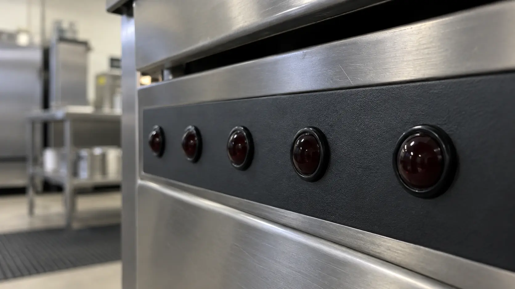Close on a row of dark indicator lights on a commercial controller.